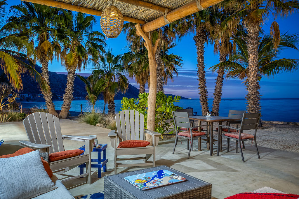 Front patio with covering and Adirondack chairs at sunset